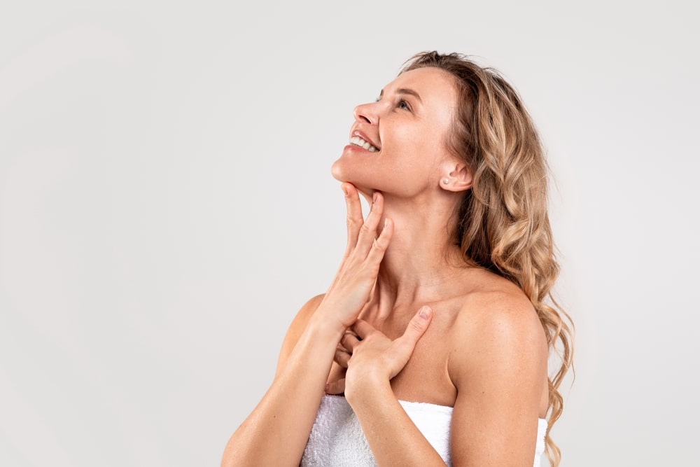 A woman touching her neck after double chin treatment with WarmSculpting