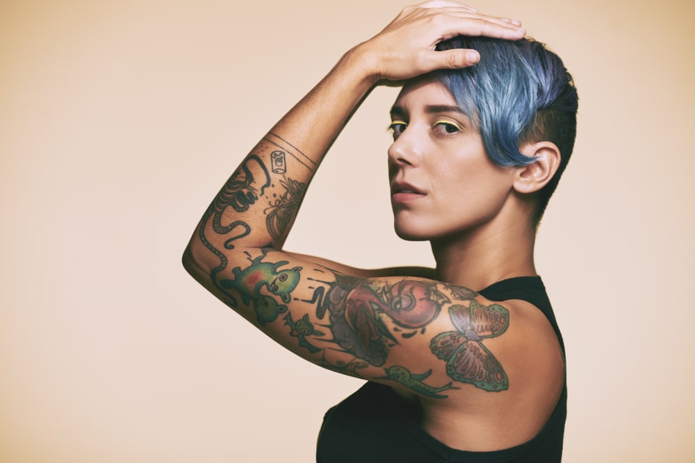 A profile shot of a woman with a tattoo sleeve